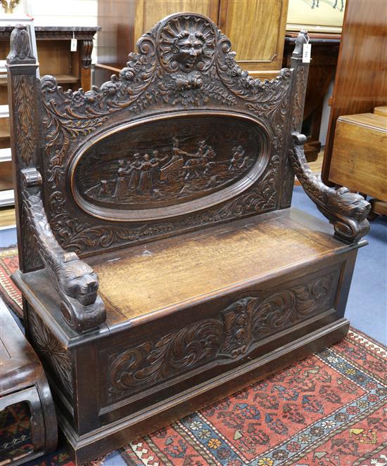 A 19th century carved oak settle W.123cm